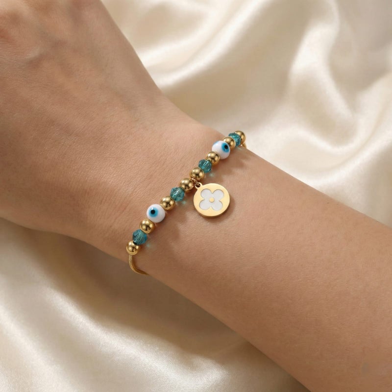 A gold bracelet made of rust-resistant stainless steel, with a thin design adorned with gold and turquoise beads and an elegant eye shape with a white rose pendant, with an adjustable clasp to fit you. - Image 4